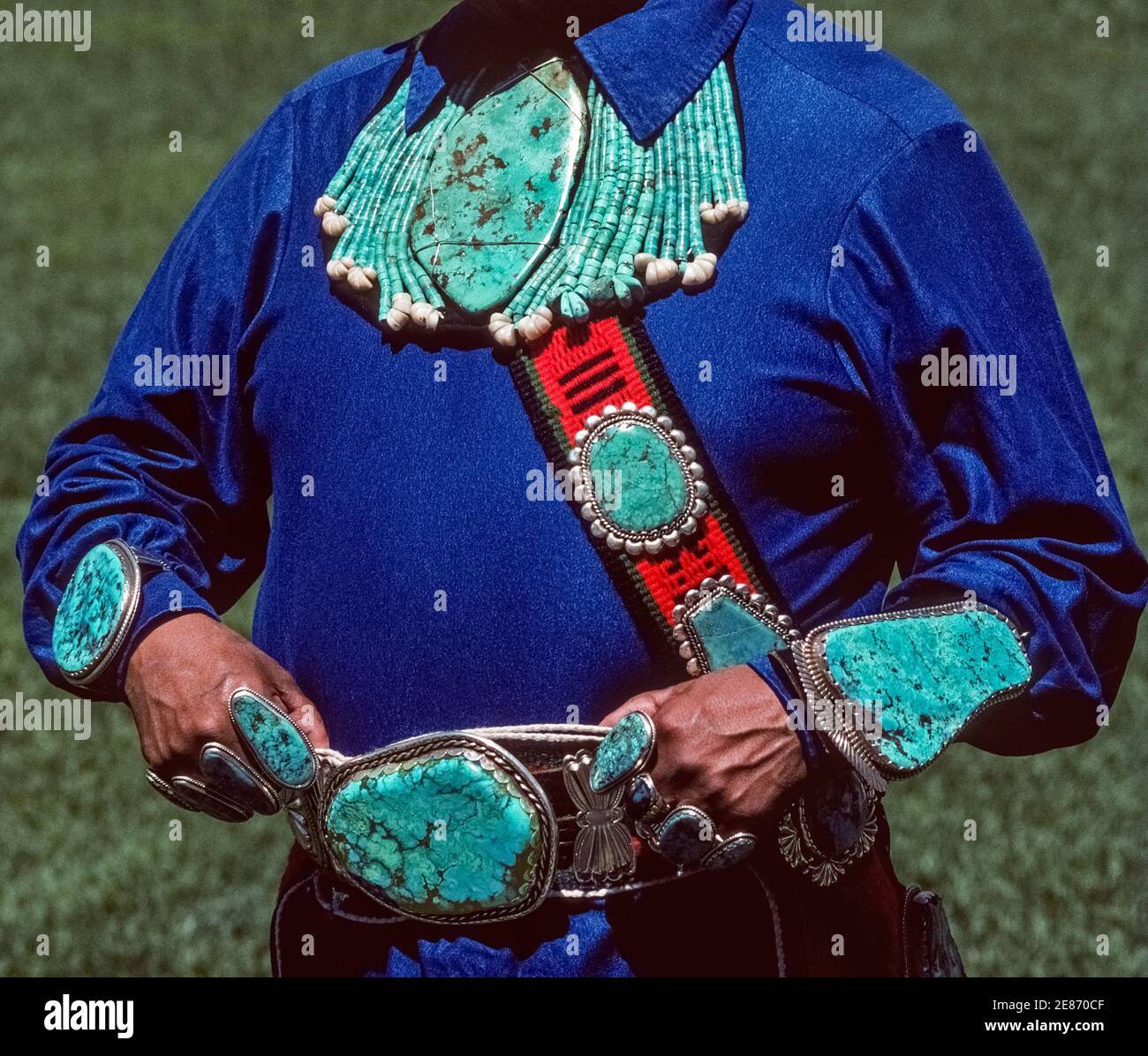 Ce magnifique bijou indien turquoise et argenté a été fabriqué et porté par un amérindien de Zuni Pueblo à Albuquerque, Nouveau-Mexique, États-Unis. Les pierres précieuses colorées bleu-vert semi-précieuses de différentes formes et tailles ont été façonnées par l'artisan indien artistique en un collier, des bracelets, des bagues, une boucle de ceinture et un bandolier accrocheur porté sur sa poitrine. La joaillerie turquoise est une forme d'art qui reflète la créativité et la culture des Amérindiens au fil des siècles, en particulier les membres de trois tribus indiennes dans le sud-ouest des États-Unis, les Navajo, Hopi et Zuni. Banque D'Images