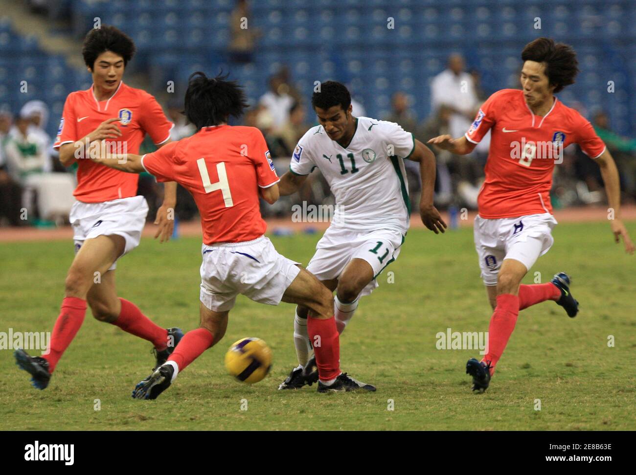 Nayaf Hazazi (11) d'Arabie saoudite se bat pour le bal avec Kim Chi Woo, Cho Yong Hkang et Ki Sung Yueng de Corée du Sud (R à L) lors de leur match de football de qualification à Riyad le 19 novembre 2008. REUTERS/Fahad Shadeed (ARABIE SAOUDITE) Banque D'Images