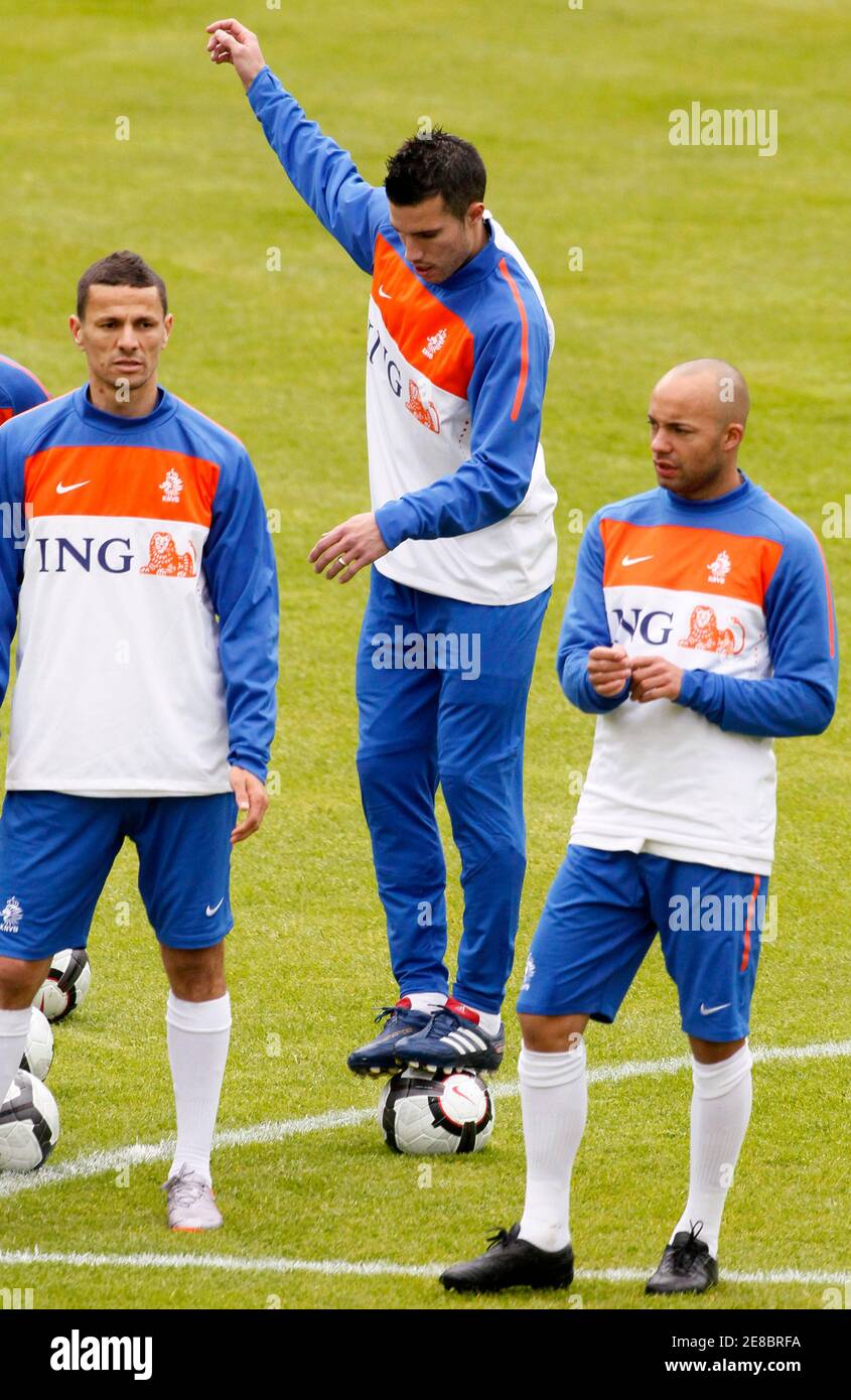 Robin van Persie (C) de l'équipe nationale de football des pays-Bas  équilibre sur un ballon tandis que les coéquipiers Kahlid Boulahrouz (L) et  Demy de Zeeuw regardent pendant une session d'entraînement à