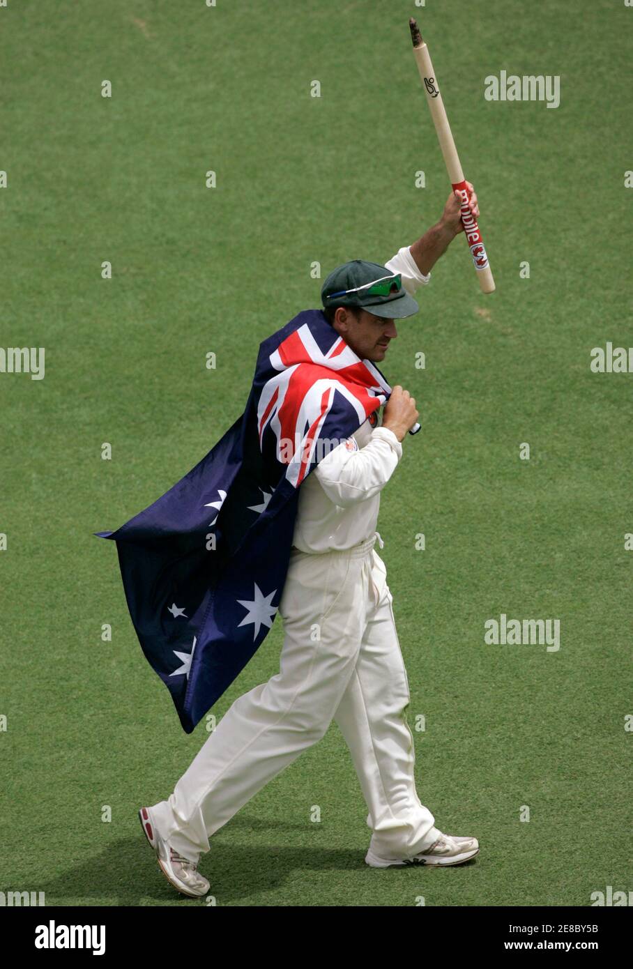 Justin Langer, de l'Australie, porte le drapeau australien et porte un cadeau souvenir après que l'Australie ait retrouvé les cendres en battant l'Angleterre le cinquième jour du troisième test de cricket à Perth le 18 décembre 2006. MOBILE OUT, USAGE ÉDITORIAL UNIQUEMENT REUTERS/WILL BURGESS (AUSTRALIE) Banque D'Images