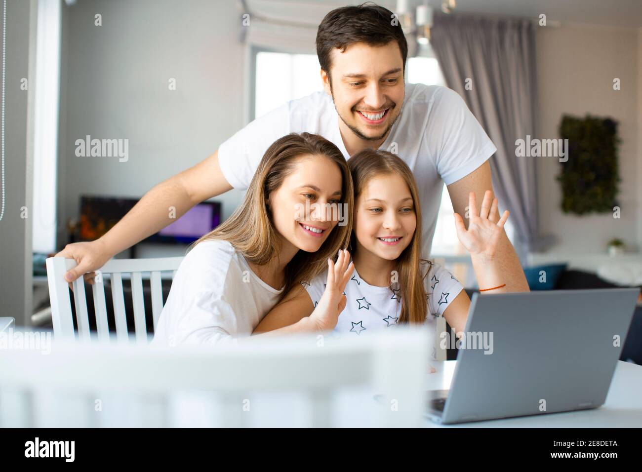 Famille heureuse pendant un appel vidéo en ligne. Communication avec des parents via Internet. Banque D'Images