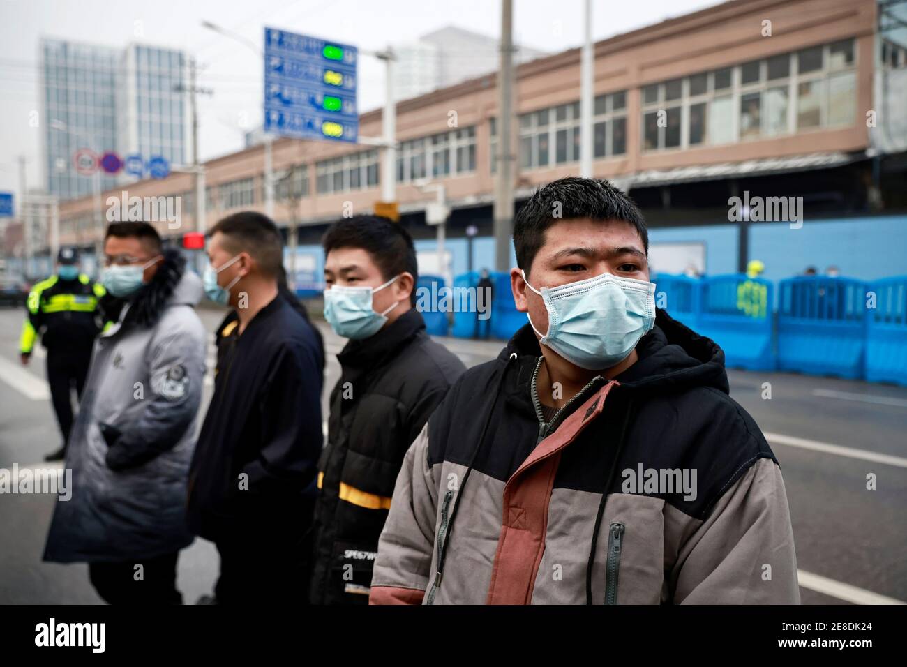Le personnel de sécurité se protège à l'extérieur du marché des produits de la mer de Huanan lors de la visite de l'équipe de l'Organisation mondiale de la santé (OMS) chargée d'enquêter sur les origines de la coronavirus (COVID-19), à Wuhan, province de Hubei, Chine le 31 janvier 2021. REUTERS/Thomas Peter Banque D'Images