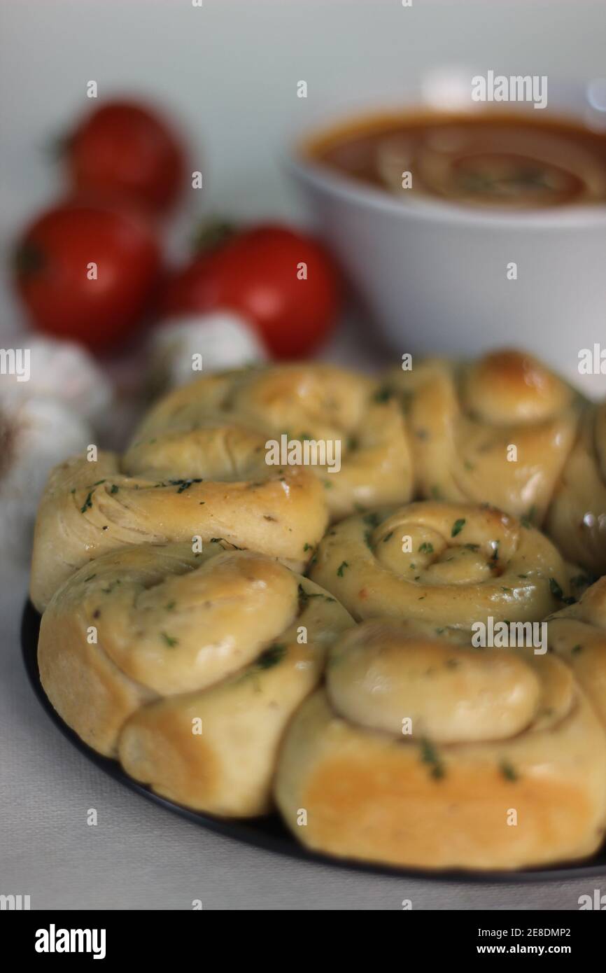 Soupe de tomates maison et un dîner fraîchement préparé Petits pains au beurre d'ail et aux herbes italiennes Banque D'Images