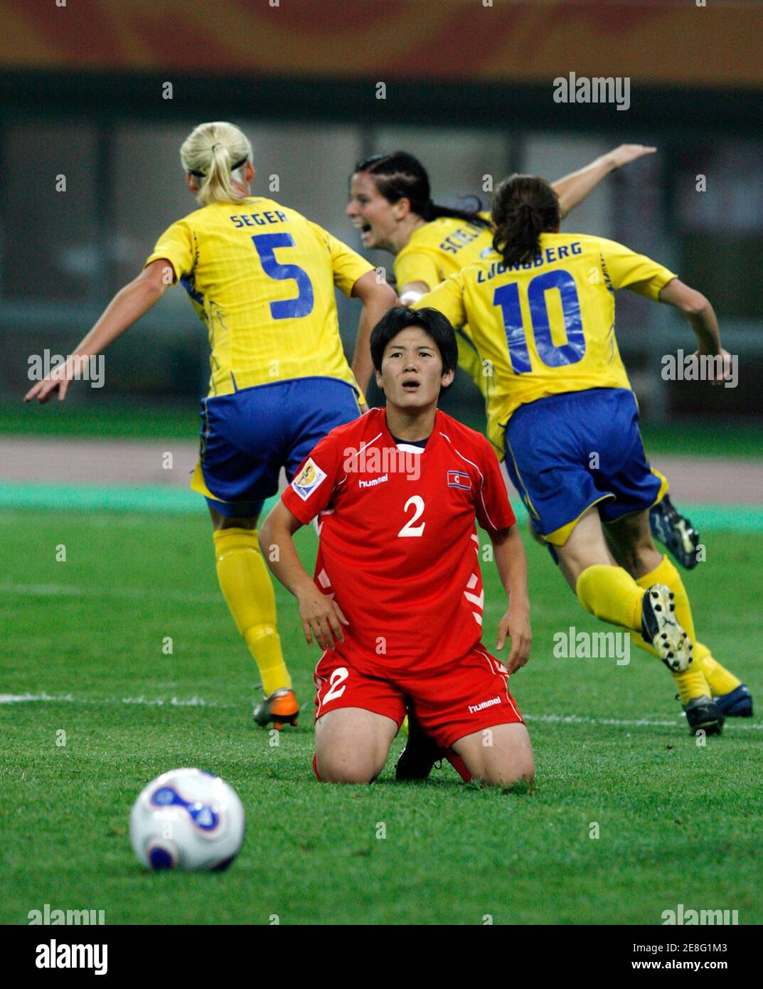 North Korea's Kim Kyong Hwa (2) reacts as Sweden's players celebrate after Charlotta Schelin (C, back) scores, chased by team mates Caroline Seger (5) and Hanna Ljungberg (10) during their Group B soccer match at the 2007 FIFA Women's World Cup in Tianjin September 18, 2007. REUTERS/Claro Cortes IV (CHINA) Banque D'Images