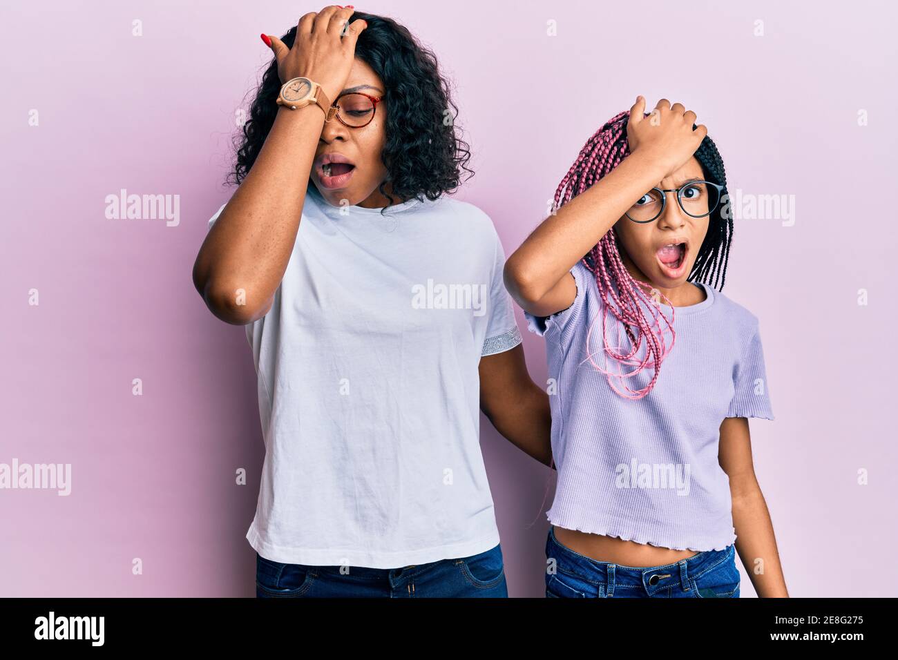 Belle mère africaine américaine et fille portant des vêtements et des lunettes décontractés surpris de main sur la tête pour erreur, souvenez-vous erreur. oublié, mauvais Banque D'Images Belle mère africaine américaine et fille portant des vêtements et des lunettes décontractés surpris de main sur la tête pour erreur, souvenez-vous erreur. oublié, mauvais Banque D'Images