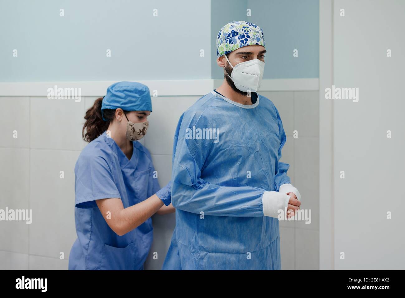 Infirmière féminine non reconnaissable, portant un uniforme stérile sur un homme médic In masque respiratoire avant la chirurgie à l'hôpital Banque D'Images