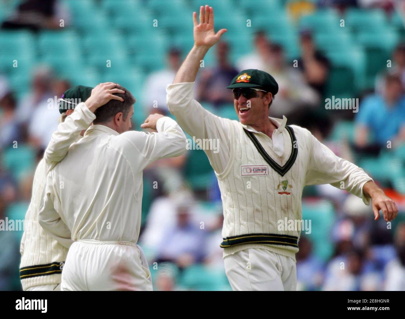Matthew Hayden, d'Australie (R), est rejoint par le coéquipier Michael Clarke (obscurci) qui félicite Stuart MacGill, qui a fait attraper Andrew Flintock du World XI pour 15 courses le quatrième jour du match de test Super Series de cricket à Sydney le 17 octobre 2005. Les XI du monde ont eu du mal à éviter une défaite massive lors du super test contre l'Australie après avoir perdu trois guichets rapides le quatrième jour de lundi. REUTERS/will Burgess Banque D'Images