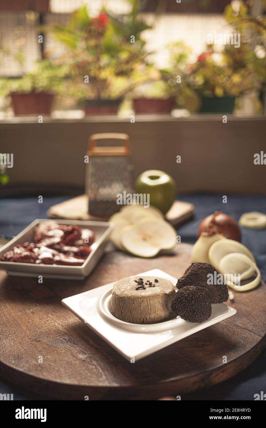 Truffes sur l'assiette près des fromages et oignons crus avec pomme sur planche à découper en interne Banque D'Images