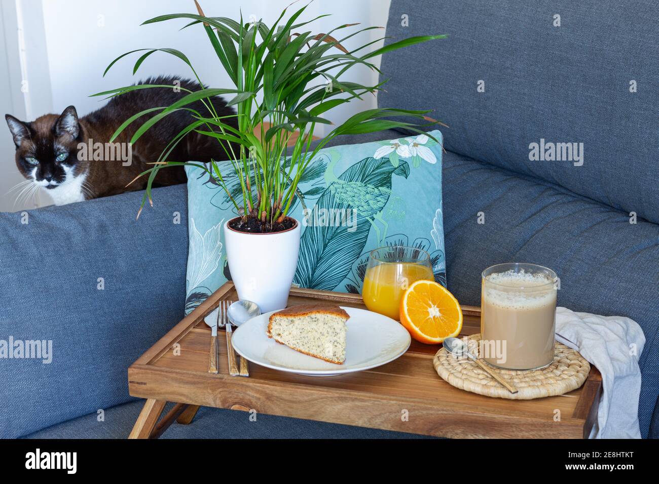 Une tasse de café et un gâteau maison en éponge placé sur du bois plateau avec un verre de jus d'orange frais préparé pour le petit déjeuner dans la salle de séjour Banque D'Images