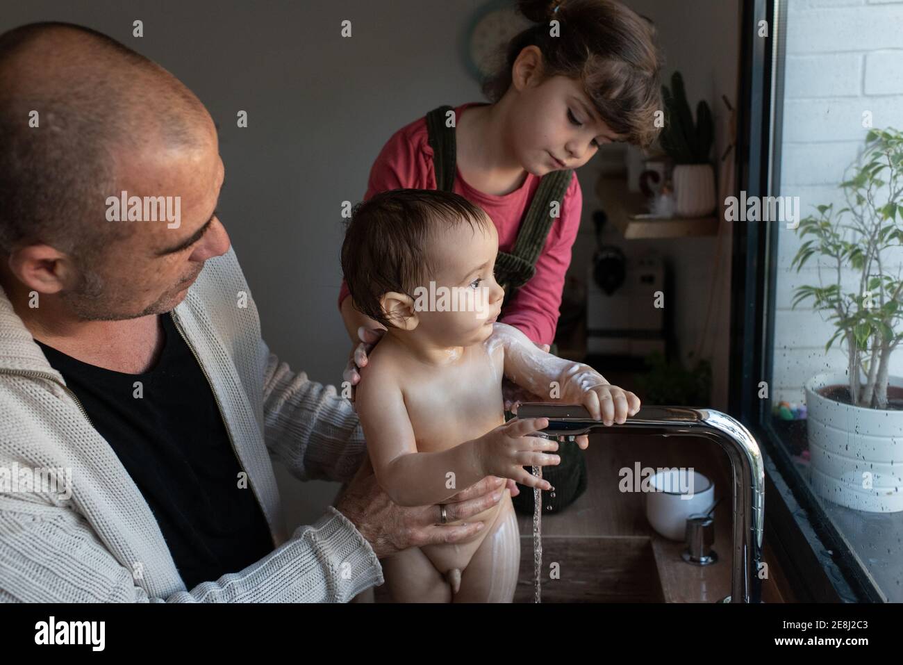Petite Fille Se Lavant La Tete De Bebe Mignon Dans Les Bras De Pere Pendant Le Bain Dans L Evier Dans La Cuisine Photo Stock Alamy