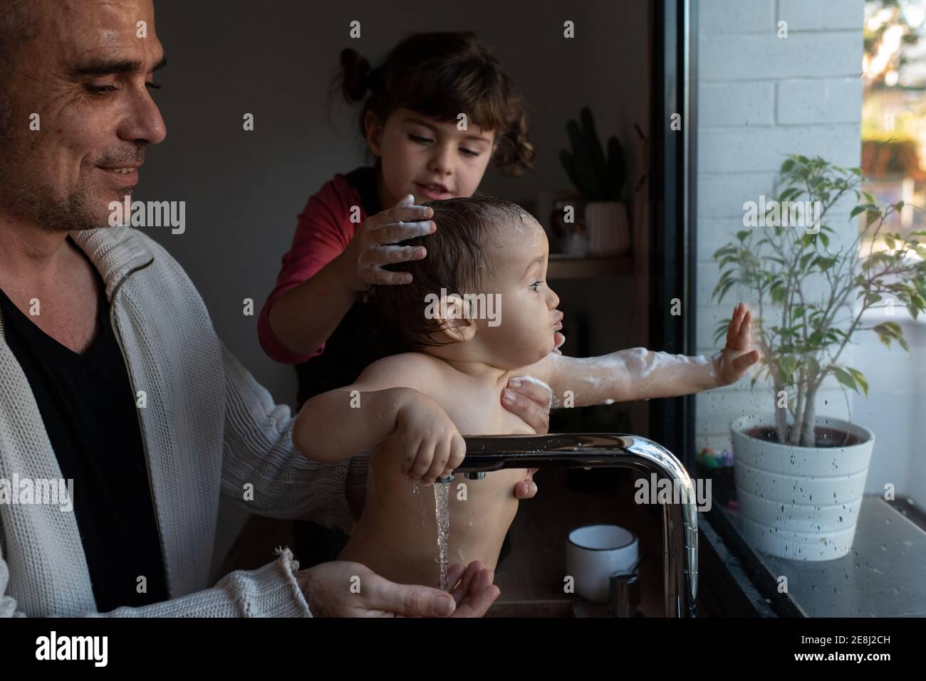 Petite Fille Se Lavant La Tete De Bebe Mignon Dans Les Bras De Pere Pendant Le Bain Dans L Evier Dans La Cuisine Photo Stock Alamy