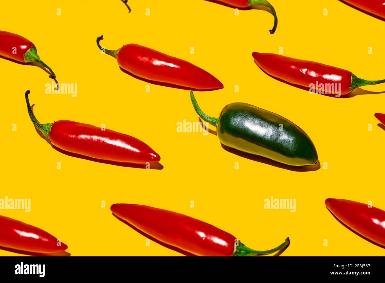De dessus de poivrons frais mûrs au piment vert chaud légume de différentes sortes sur fond jaune Banque D'Images