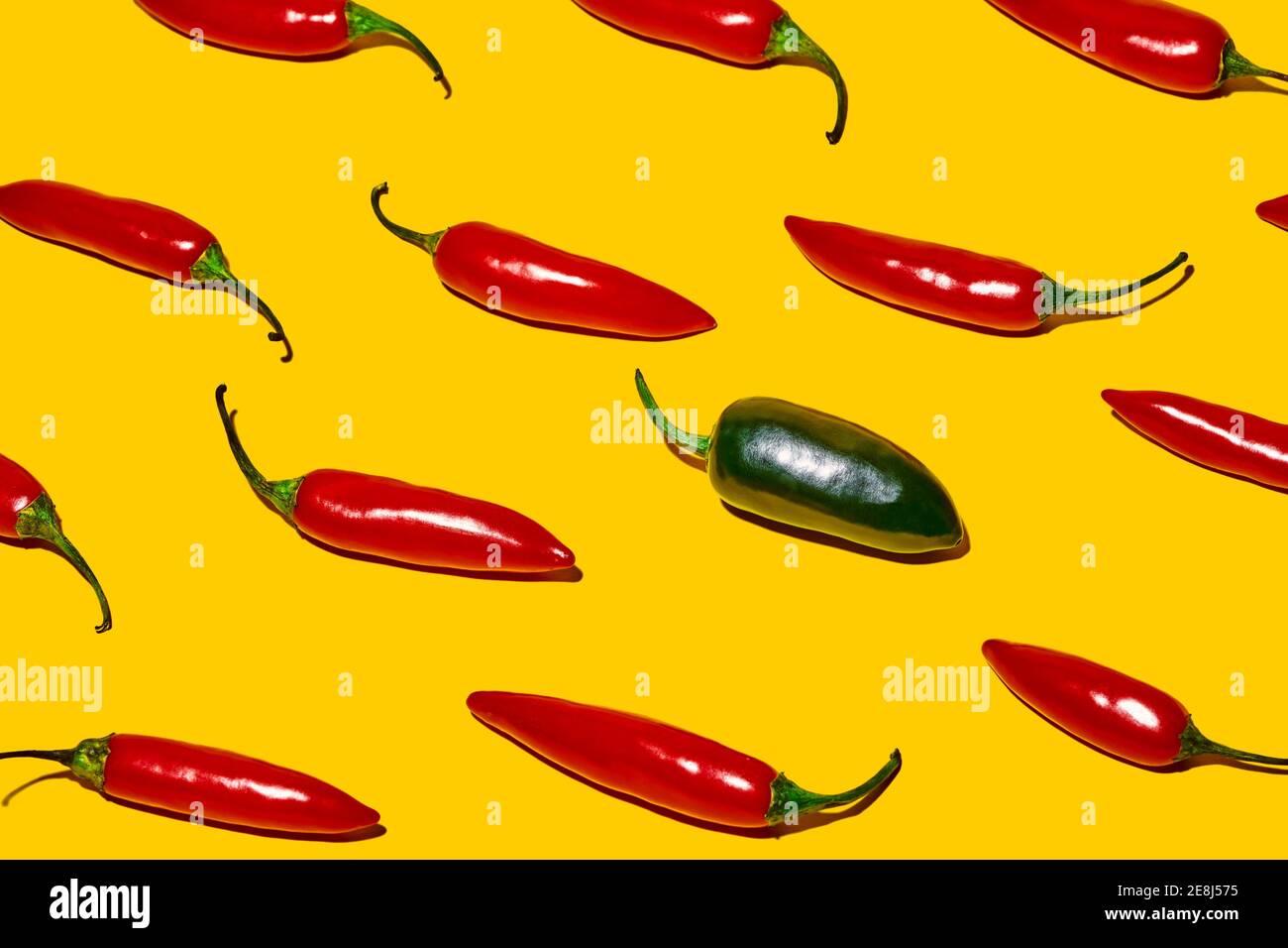 De dessus de poivrons frais mûrs au piment vert chaud légume de différentes sortes sur fond jaune Banque D'Images