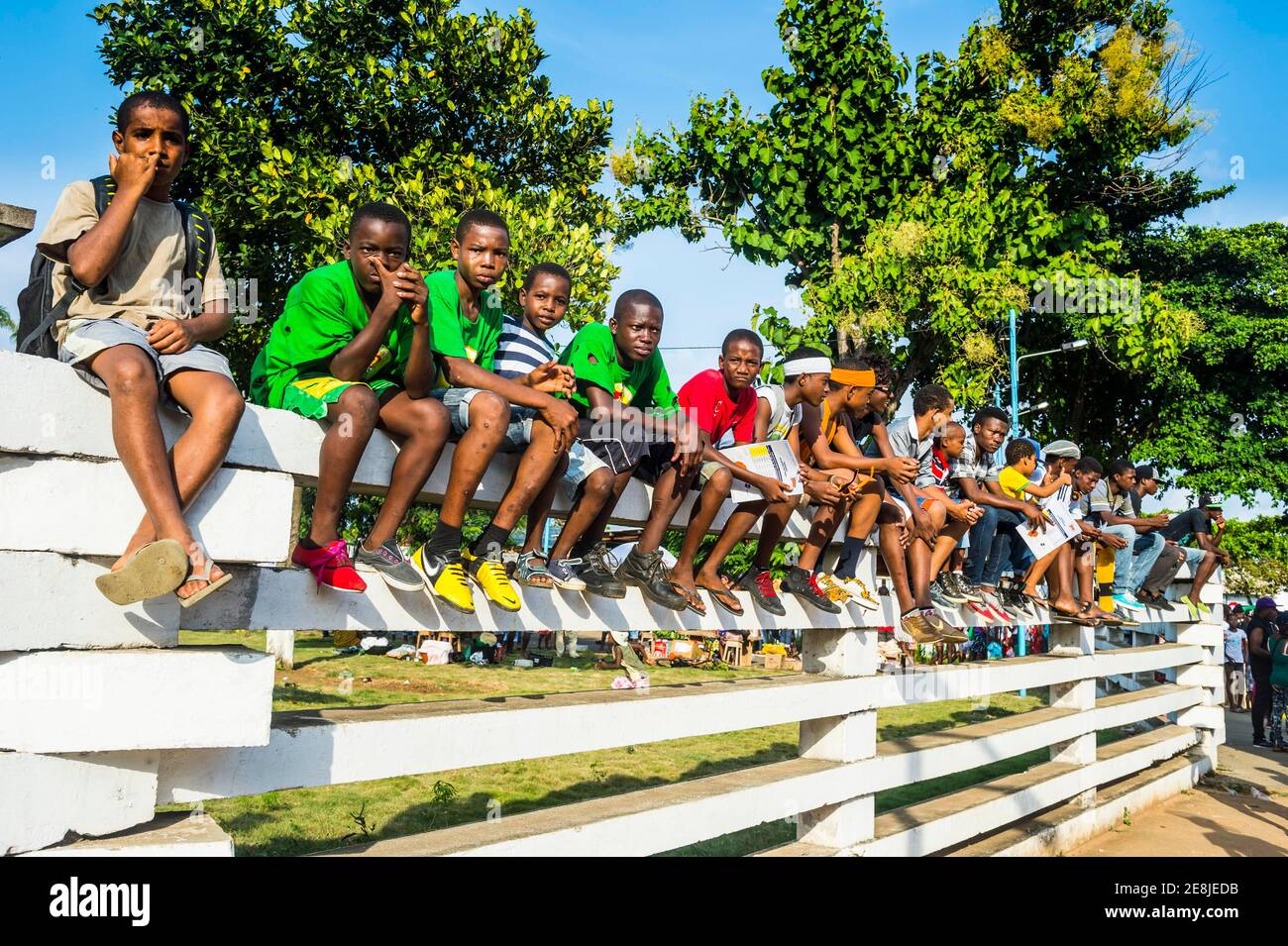 Des garçons sur un mur regardant le défilé de Carneval dans la ville de Sao Tomé, Sao Tomé-et-principe, océan Atlantique Banque D'Images