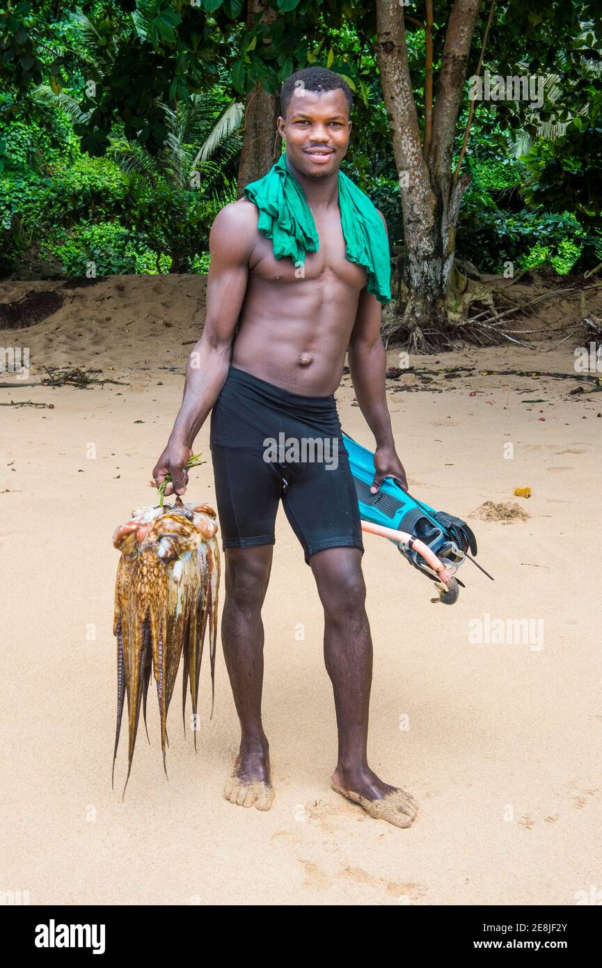 Homme présentant sa calamar fraîche, plage Praia do Inhame, côte sud de Sao Tomé, Sao Tomé-et-principe, océan Atlantique Banque D'Images
