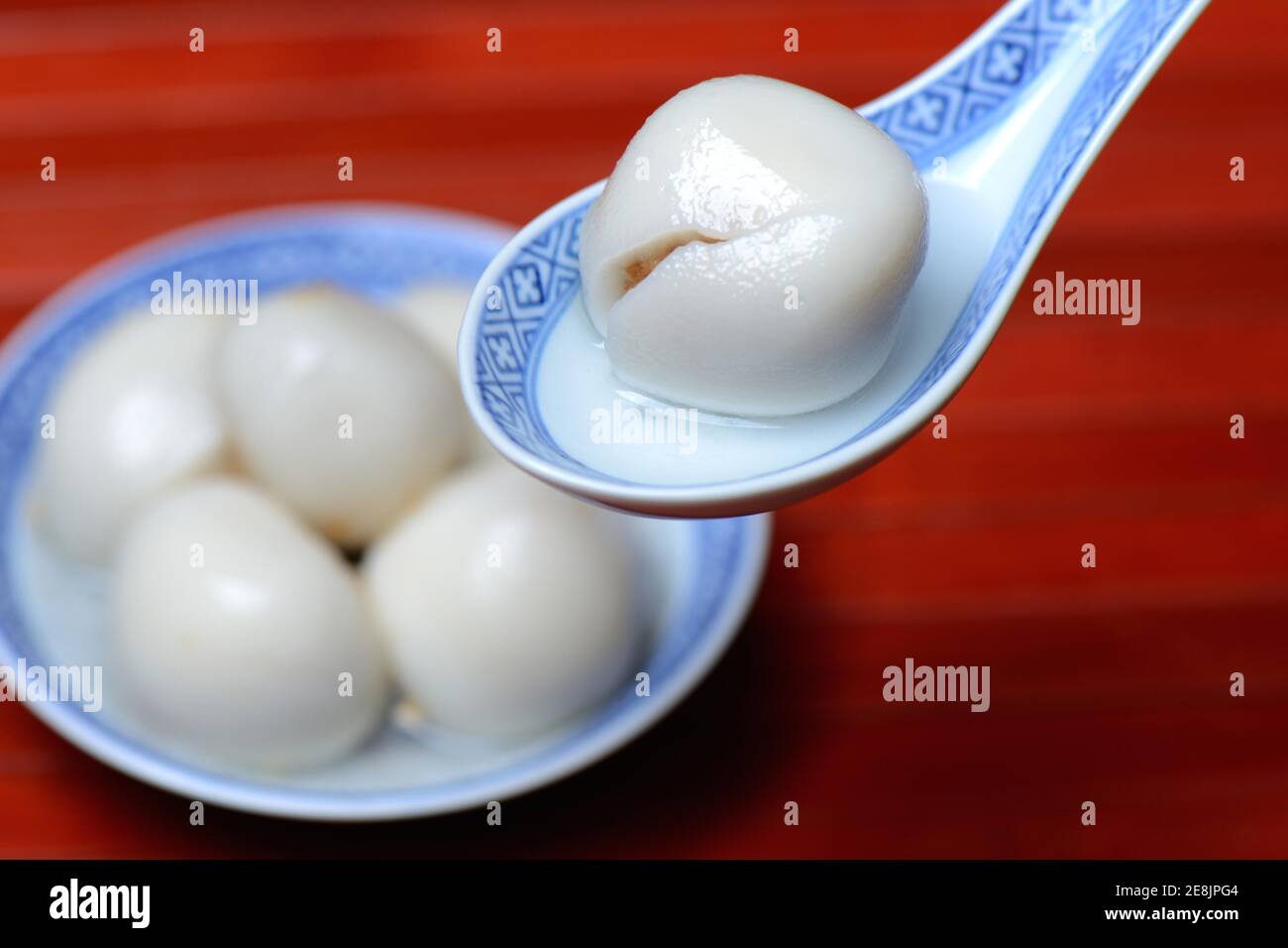 Boulettes de riz gluant avec garniture d'arachide dans un bol et une cuillère Banque D'Images