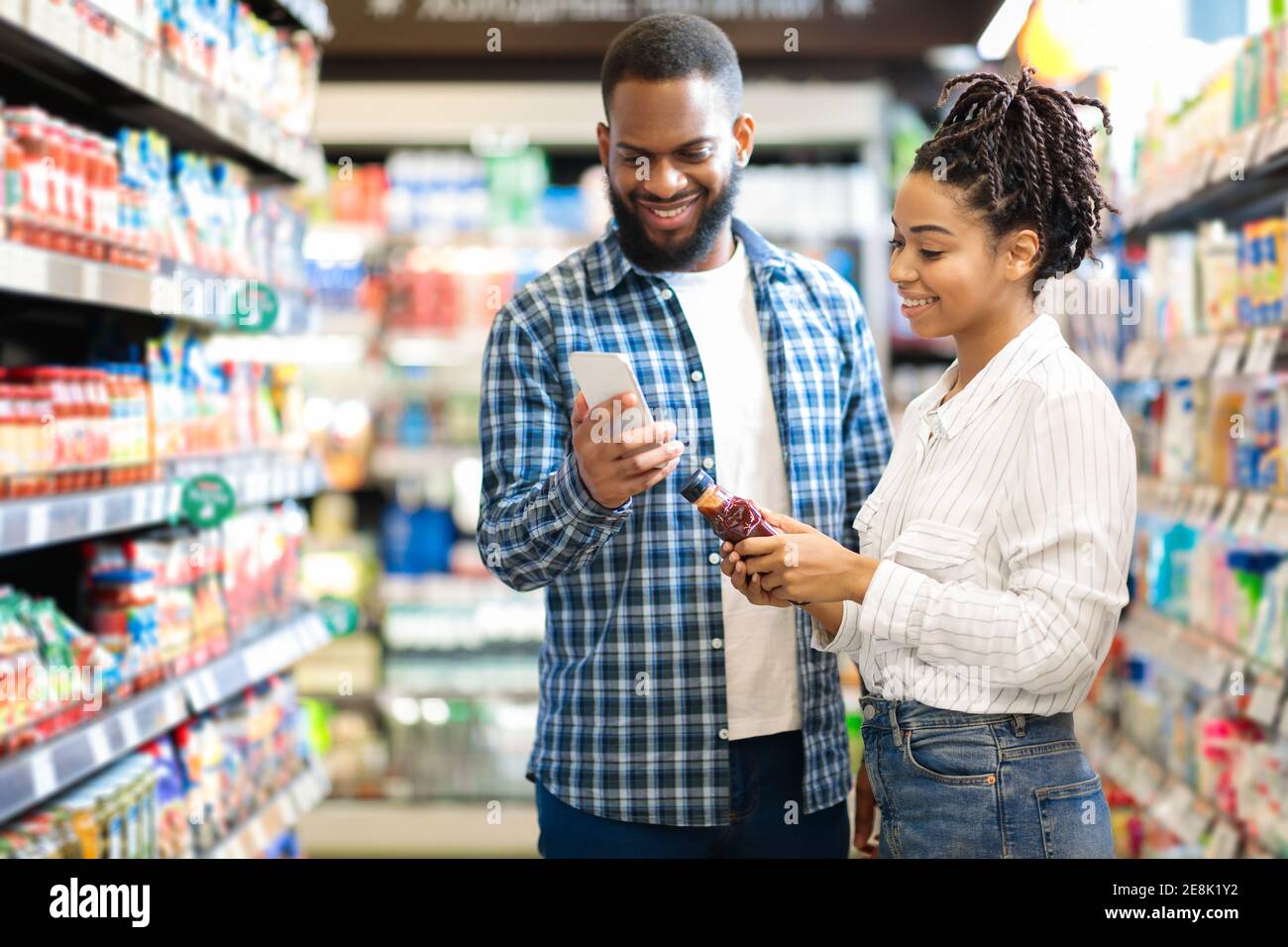 Black Family faire de l'épicerie Shopping au supermarché, en utilisant le téléphone à l'intérieur Banque D'Images