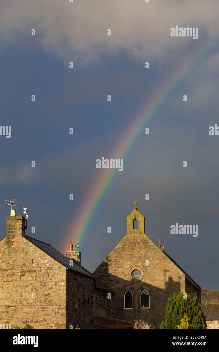 Un arc-en-ciel illumine le ciel au-dessus de l'église de l'église victorienne d'Angleterre maintenant redondante dans le village de Melkridge, Northumberland, Royaume-Uni Banque D'Images