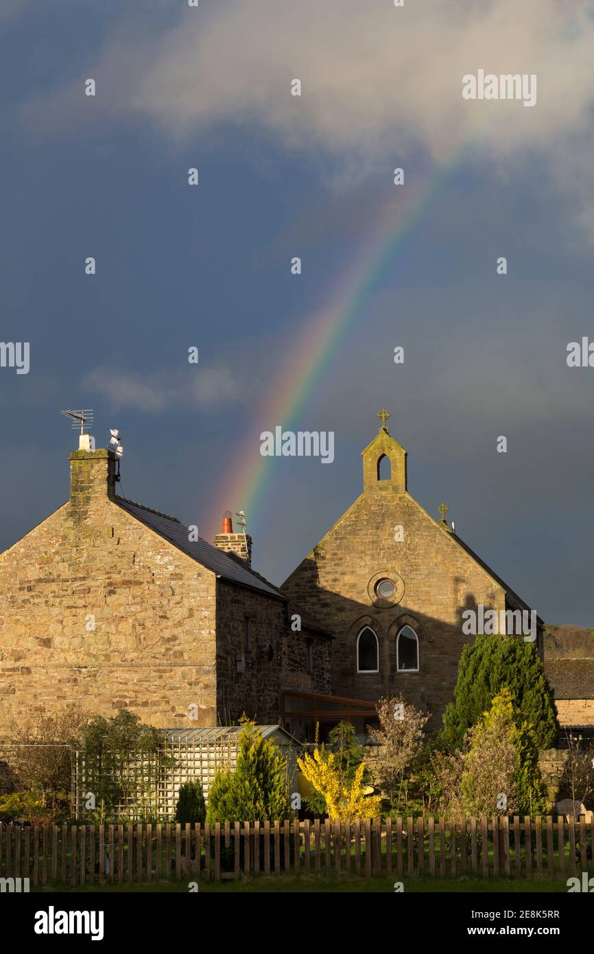 Un arc-en-ciel illumine le ciel au-dessus de l'église de l'église victorienne d'Angleterre maintenant redondante dans le village de Melkridge, Northumberland, Royaume-Uni Banque D'Images