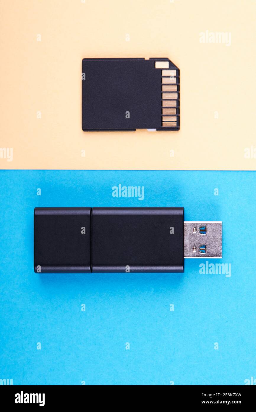 clé usb et carte mémoire micro sd sur fond bleu et jaune. différents types de périphériques de stockage portables. concept de stockage de données Banque D'Images