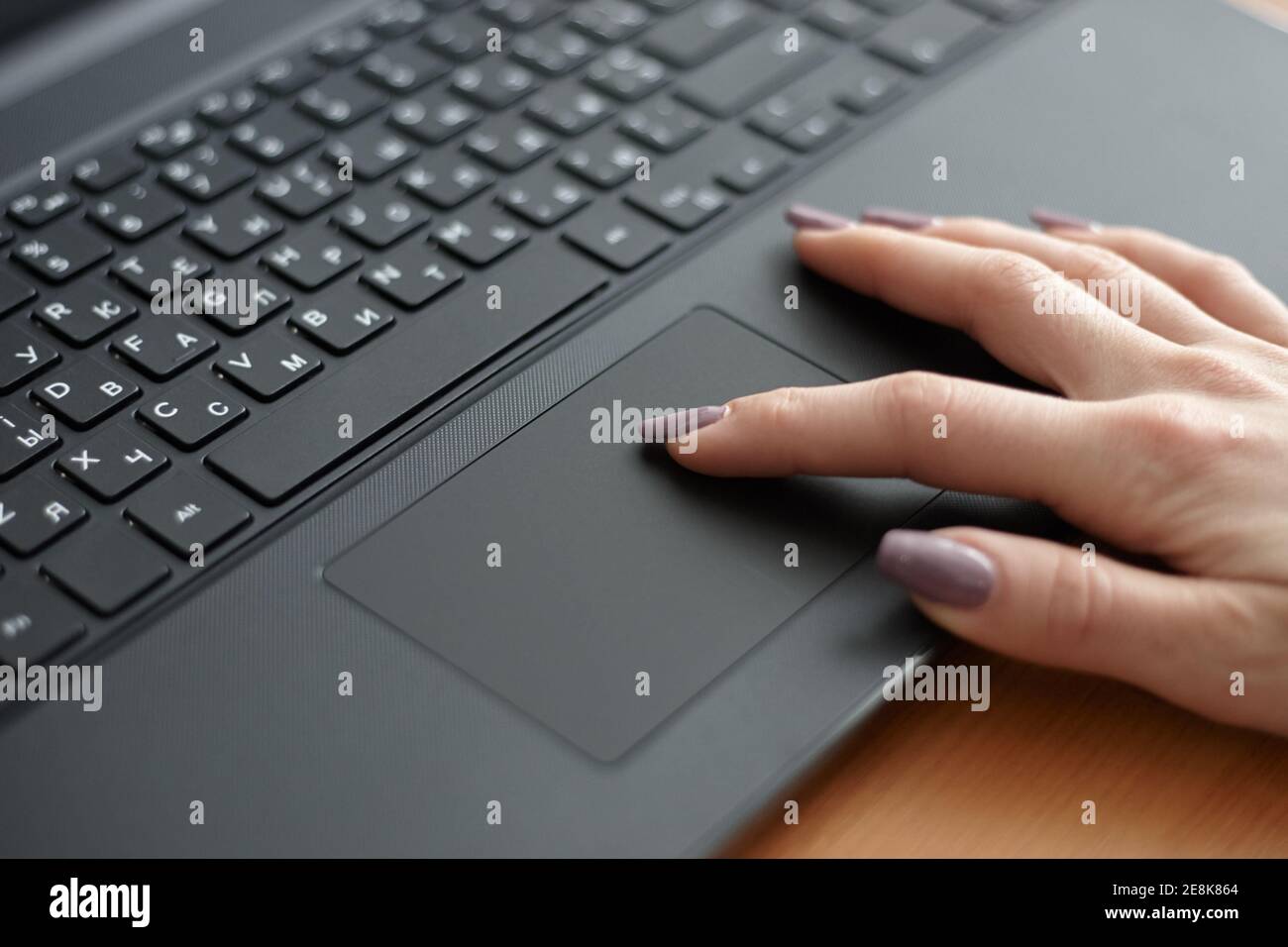 Femme utilisant un ordinateur portable noir pour travailler. Surfer sur Internet à l'aide du pavé tactile. Concept d'entreprise Banque D'Images