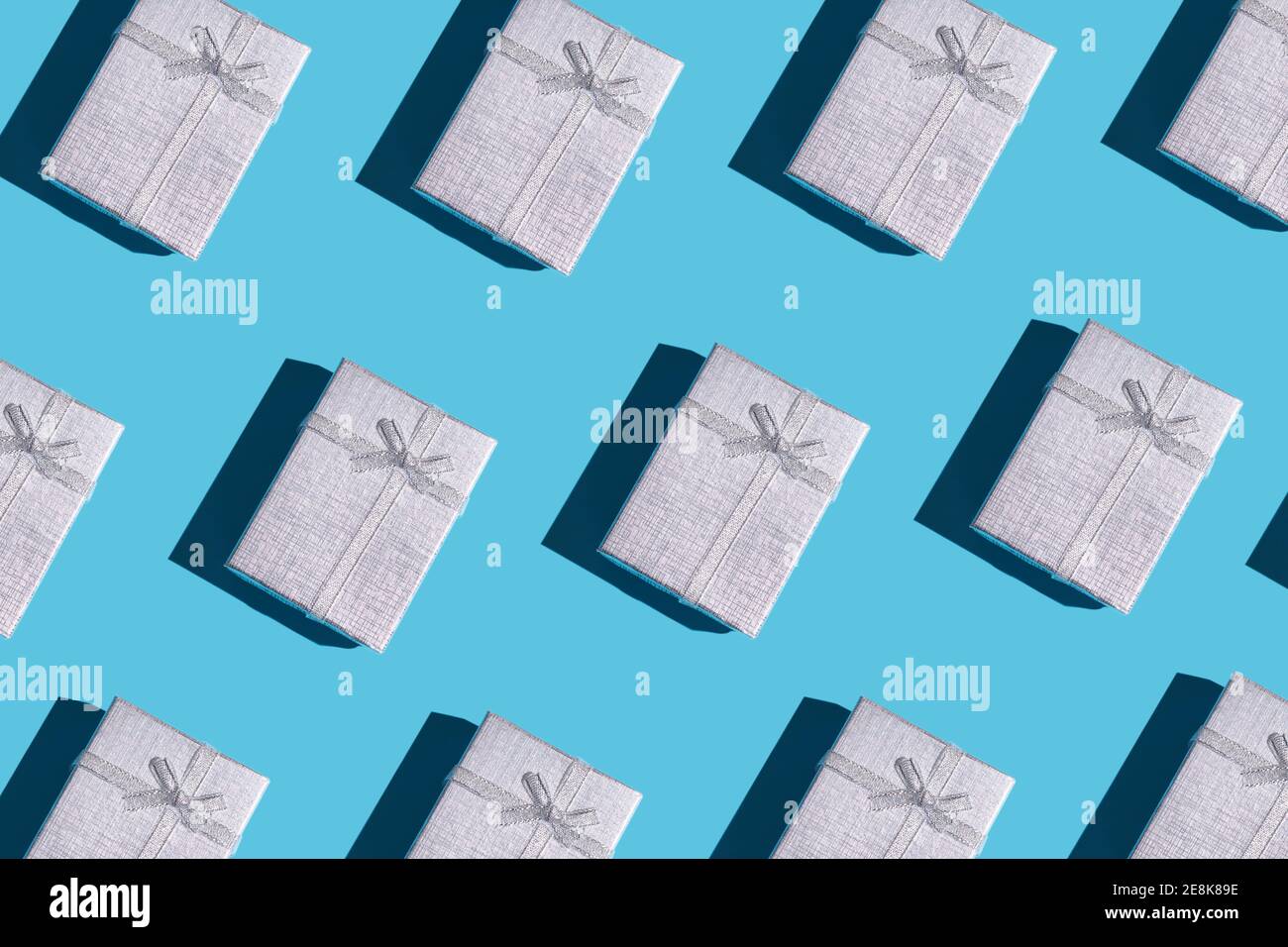 boîtes-cadeaux de couleur argent avec arrière-plan ombré dur. rangées de boîtes. flat lay Banque D'Images