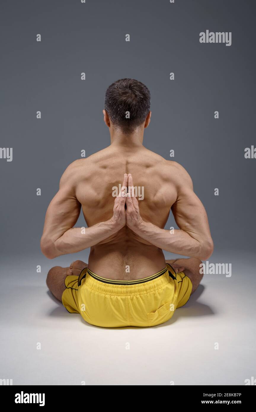 Le yoga est assis avec les mains derrière le dos Banque D'Images