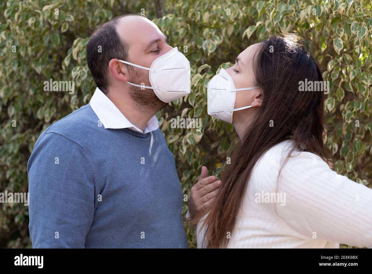 Couple amoureux, homme et femme s'embrassant dans un masque médical protecteur sur le visage de la rue asiatique. Concept de pollution de l'environnement. Guy, fille Banque D'Images