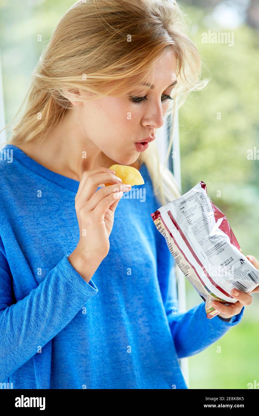 Fille mangeant un sac de chips Banque D'Images