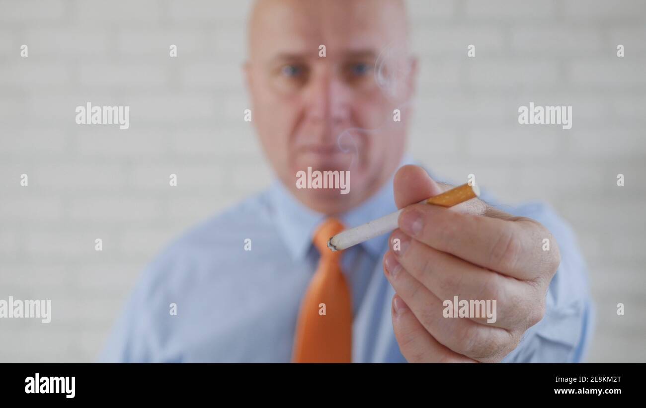 Image avec un homme d'affaires fumant une cigarette. La fumée et la dépendance à la nicotine causent de graves problèmes de santé. Banque D'Images
