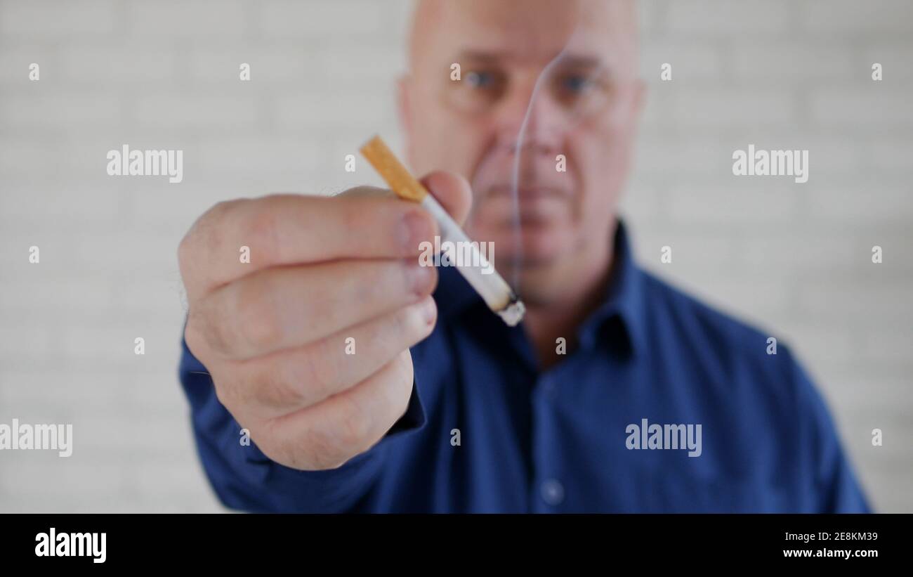 Image avec un homme d'affaires fumant une cigarette. La fumée et la dépendance à la nicotine causent de graves problèmes de santé. Banque D'Images
