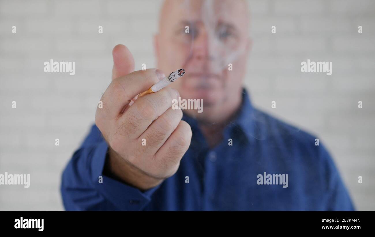 Image avec un homme d'affaires fumant une cigarette. La fumée et la dépendance à la nicotine causent de graves problèmes de santé. Banque D'Images