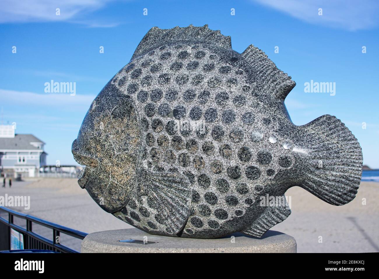 Hampton Beach State Park - Hampton, New Hampshire - UNE sculpture d'un poisson sculpté dans la pierre repose sur le pilier de la clôture le long de la promenade sur un Banque D'Images