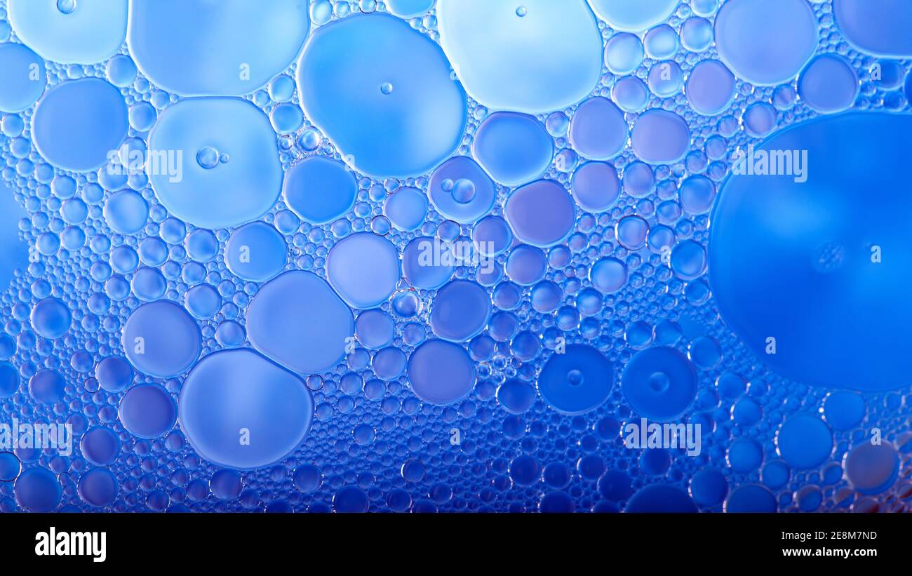 Huile mélangée à de l'eau, fond bleu abstrait Banque D'Images