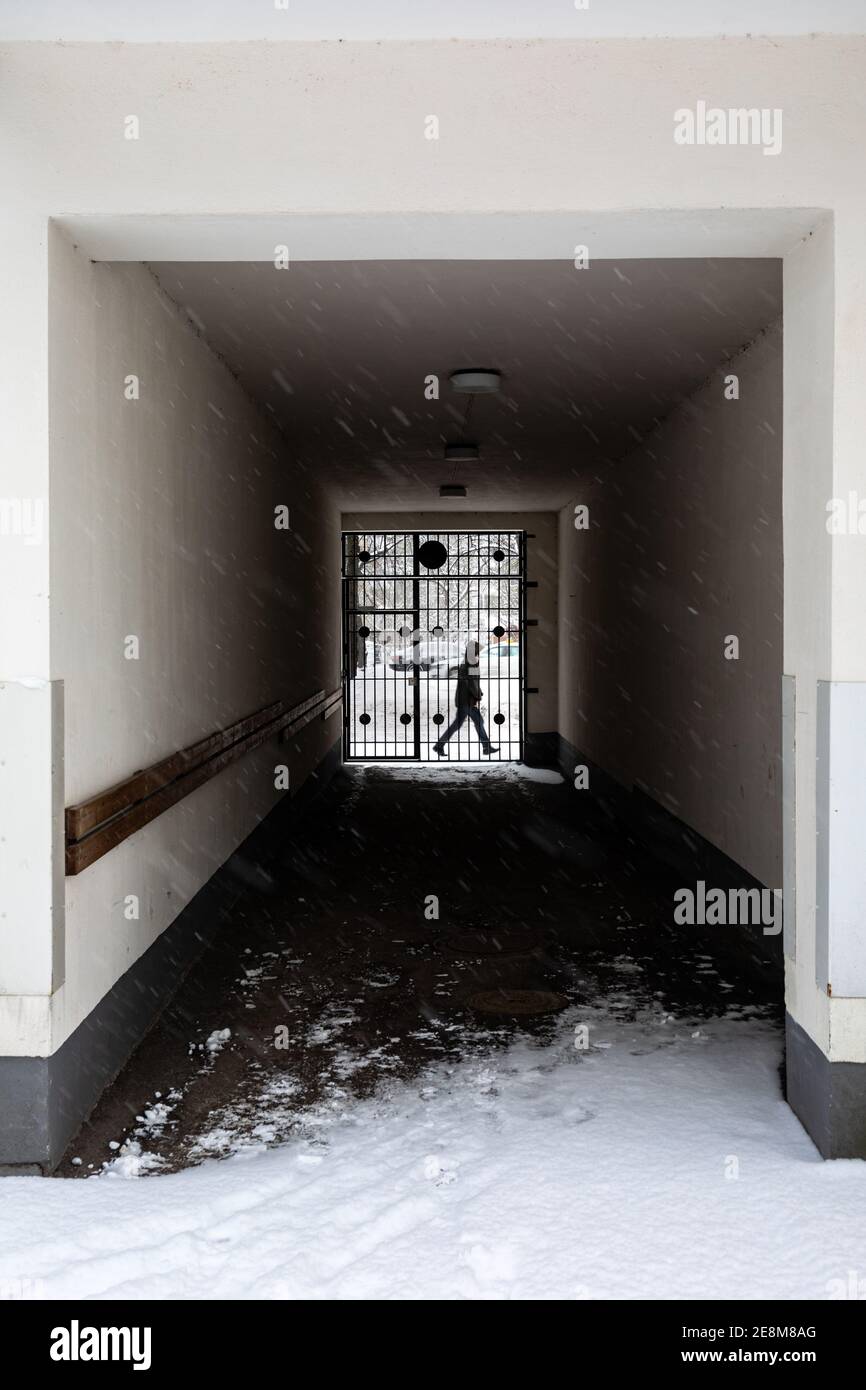 Porte d'entrée de cour intérieure à rue avec la silhouette d'un passer derrière la porte Banque D'Images