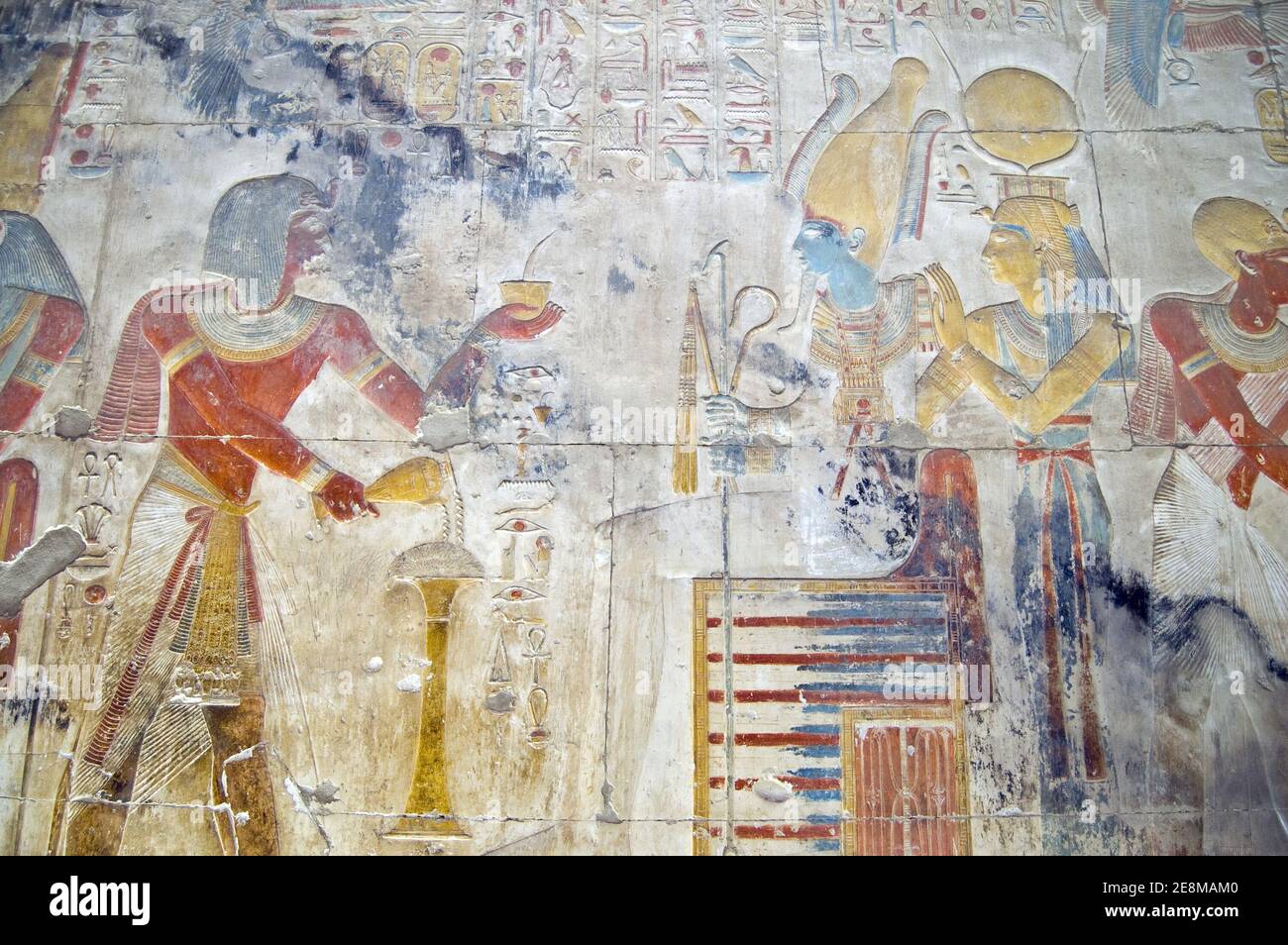 Sculpture égyptienne antique montrant le Pharaon Seti I faisant une offrande au dieu du monde inférieur Osiris avec la déesse Isis. Mur du temple Banque D'Images
