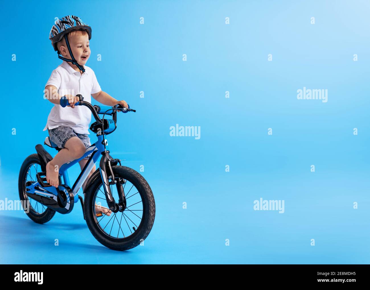 Mignon, petit garçon apprendre à faire du vélo Banque D'Images