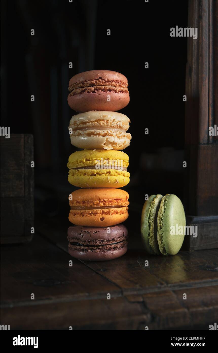 Pile de délicieux macarons français classiques ou macarons sur un vieux panneau latéral sombre vintage Banque D'Images