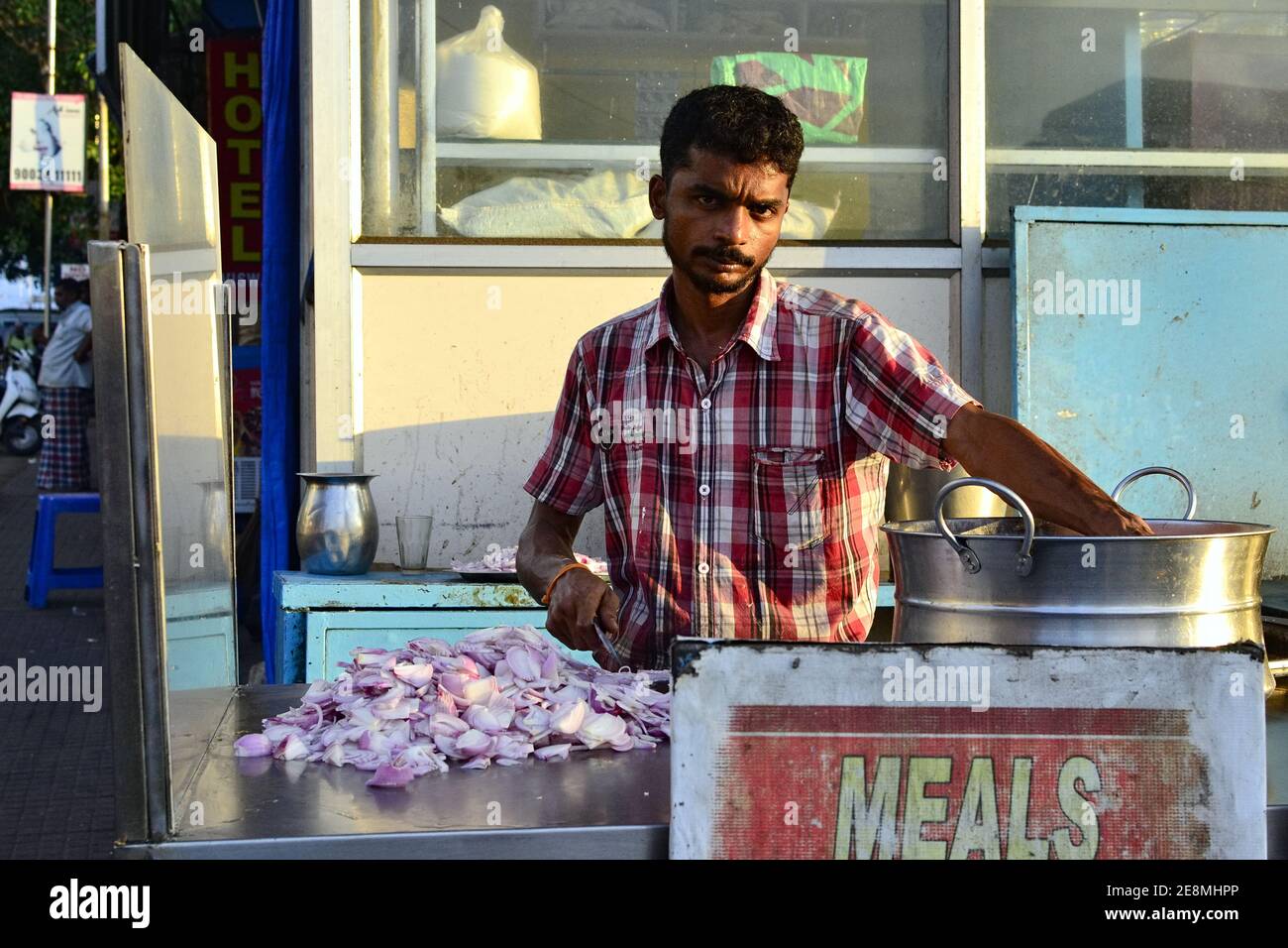 Kanyakumari, Tamil Nadu, Inde - février 2017 : un Indien qui coupe l'oignon pour cuisiner de la nourriture de rue dans un petit café de la rue Banque D'Images