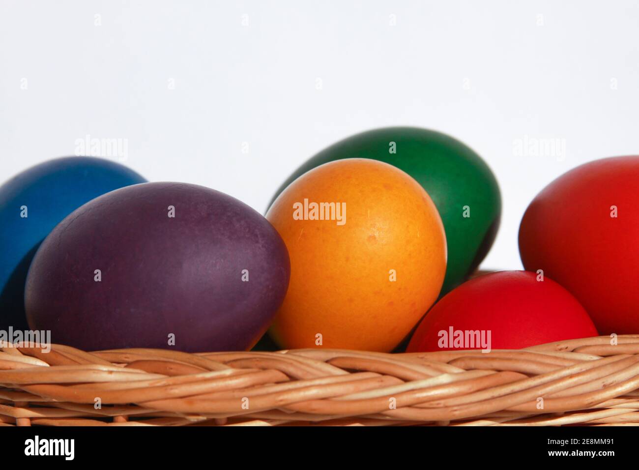 Œufs de Pâques peints en couleur dans une décoration de panier en bois en préparation des vacances. Peindre des oeufs de poulet ou de canard est une tradition chrétienne à célébrer Banque D'Images