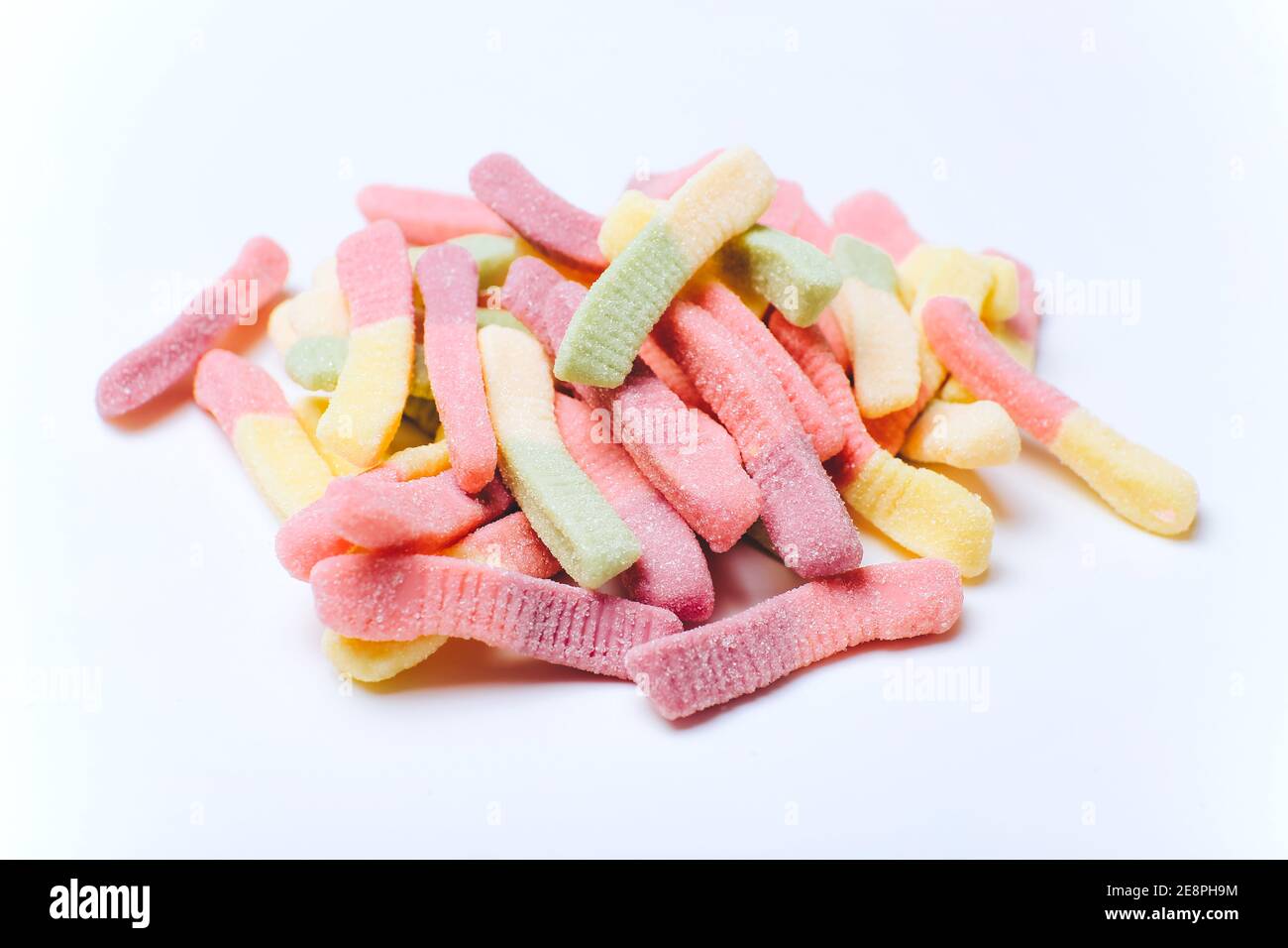 Pile de bonbons colorés pastel délicieux sur fond blanc Banque D'Images