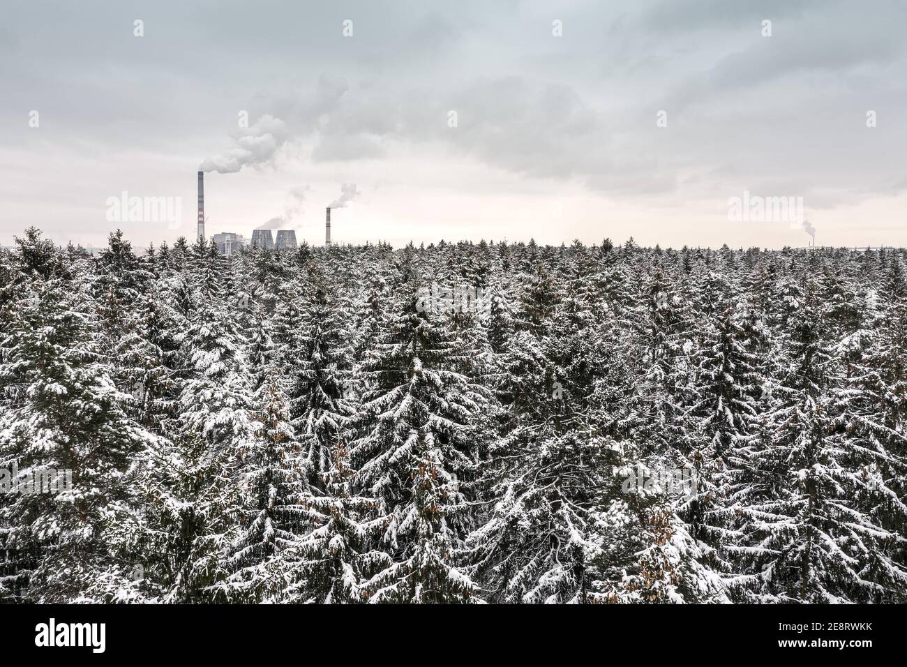 forêt d'hiver d'en haut. centrale thermique avec cheminées à l'horizon. concept photo aérienne Banque D'Images