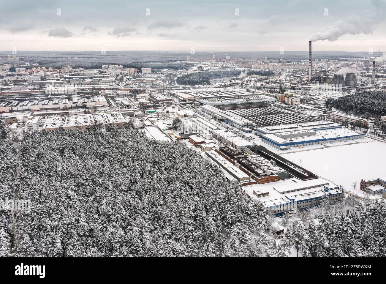 zone industrielle urbaine en hiver. bâtiments d'usine, entrepôts et centrale thermique sur fond ciel couvert. vue aérienne Banque D'Images