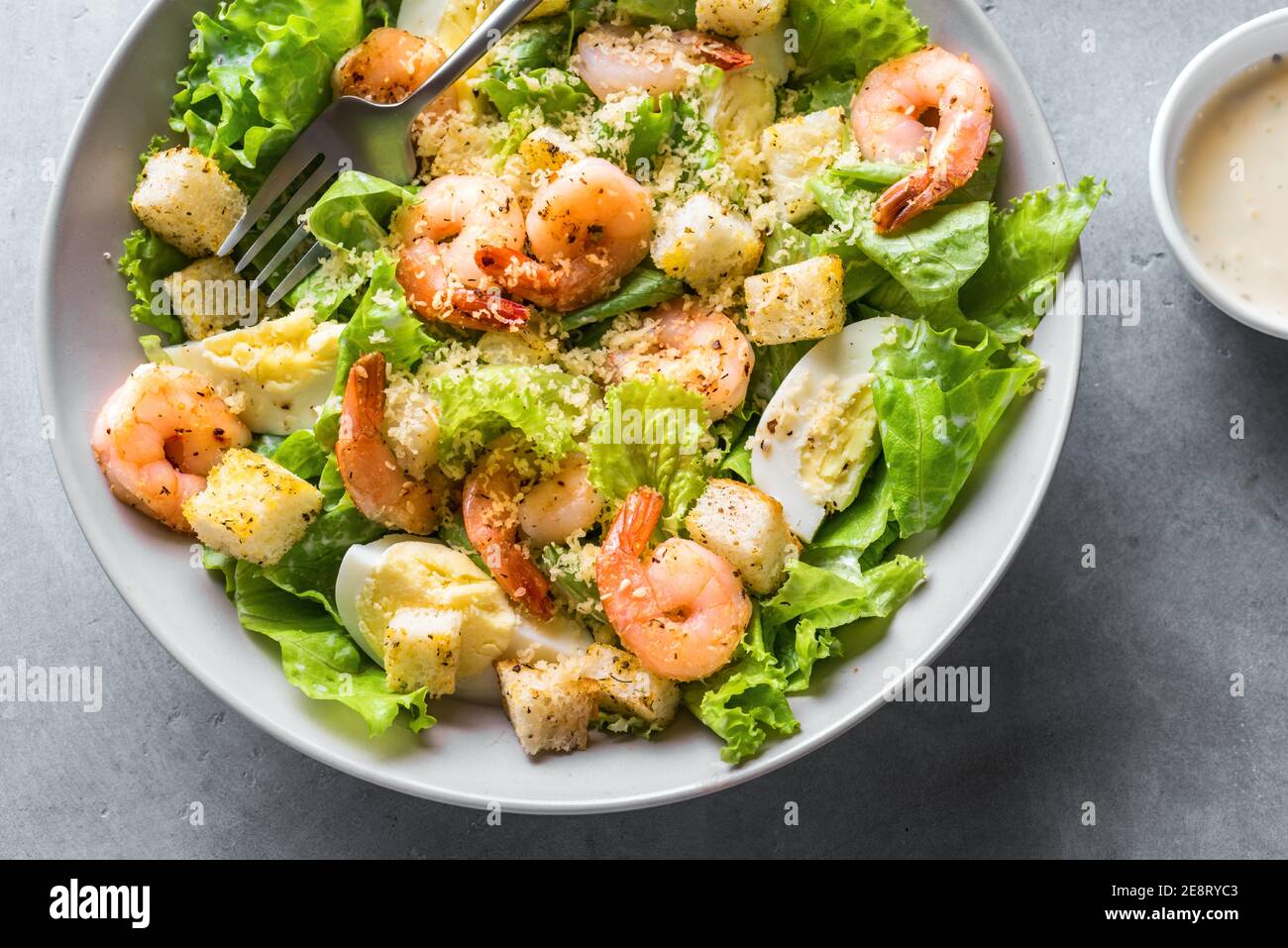 Salade de crevettes. Salade César aux fruits de mer sur fond de pierre grise. Banque D'Images