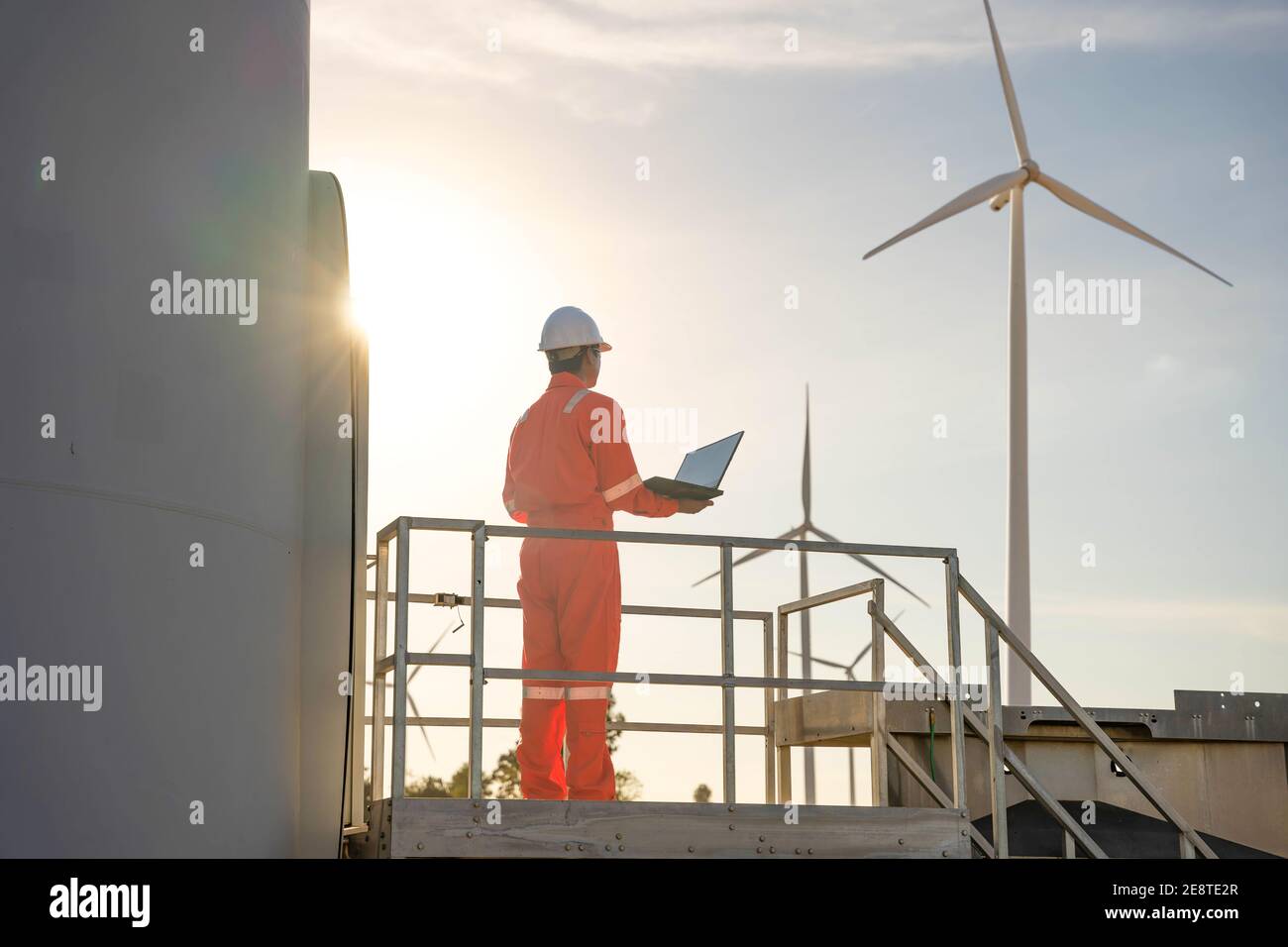 Homme ingénieur travaillant et tenant l'ordinateur portable pour vérifier les performances de la centrale éolienne, concept de ressources durables, Conc Banque D'Images