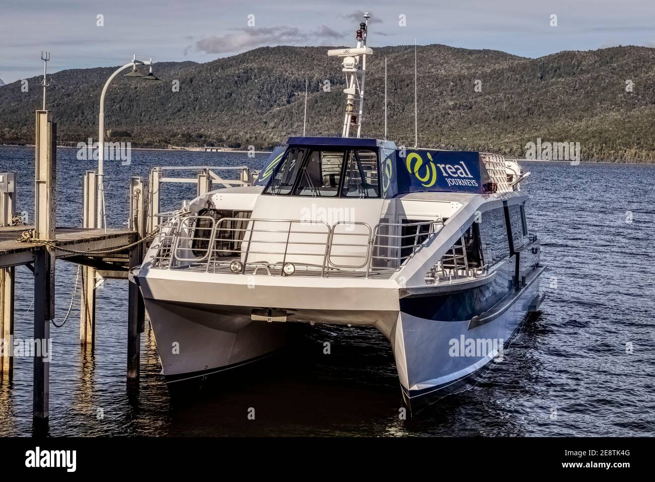 Un véritable catamaran Journeys amarré à la jetée sur le lac te Anau dans le parc national du Fiordland, île du Sud, Nouvelle-Zélande. Banque D'Images