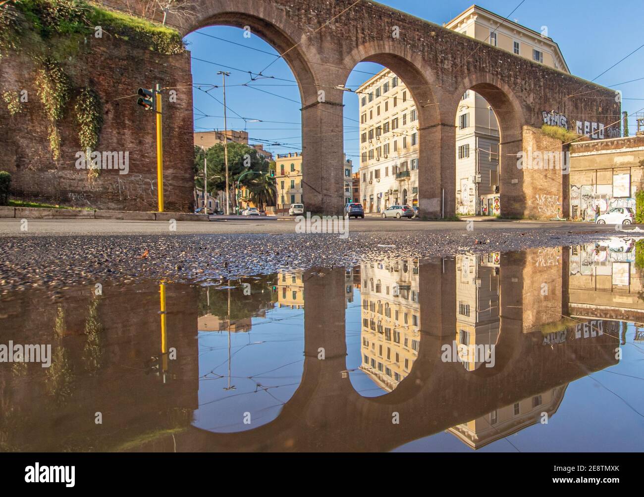 Les fréquentes averses de pluie créent des piscines dans lesquelles la merveilleuse vieille ville de Rome se reflète comme dans un miroir. Ici en particulier la Piazza di Porta Maggiore Banque D'Images