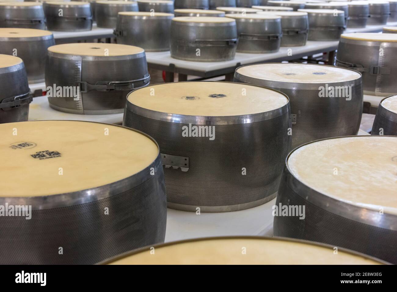 Parmigiano reggiano fromage dans des moules en métal pour le façonner en les tours sont prêts à être stockés et à mûrir dans Bologne Italie Banque D'Images