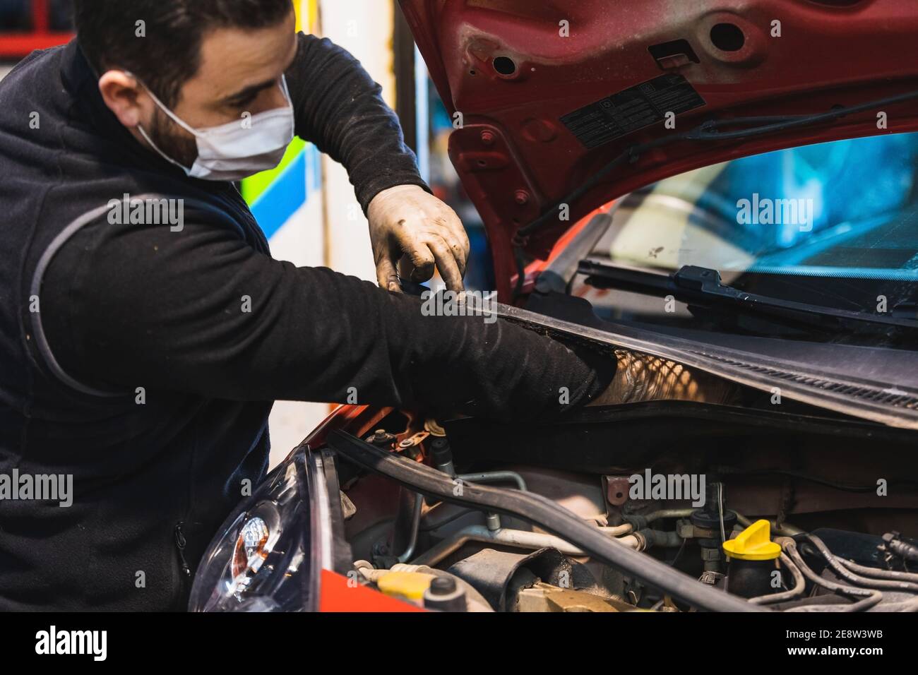 mécanicien répare la voiture . Concentrez-vous sur les mains. COVID 19 Banque D'Images