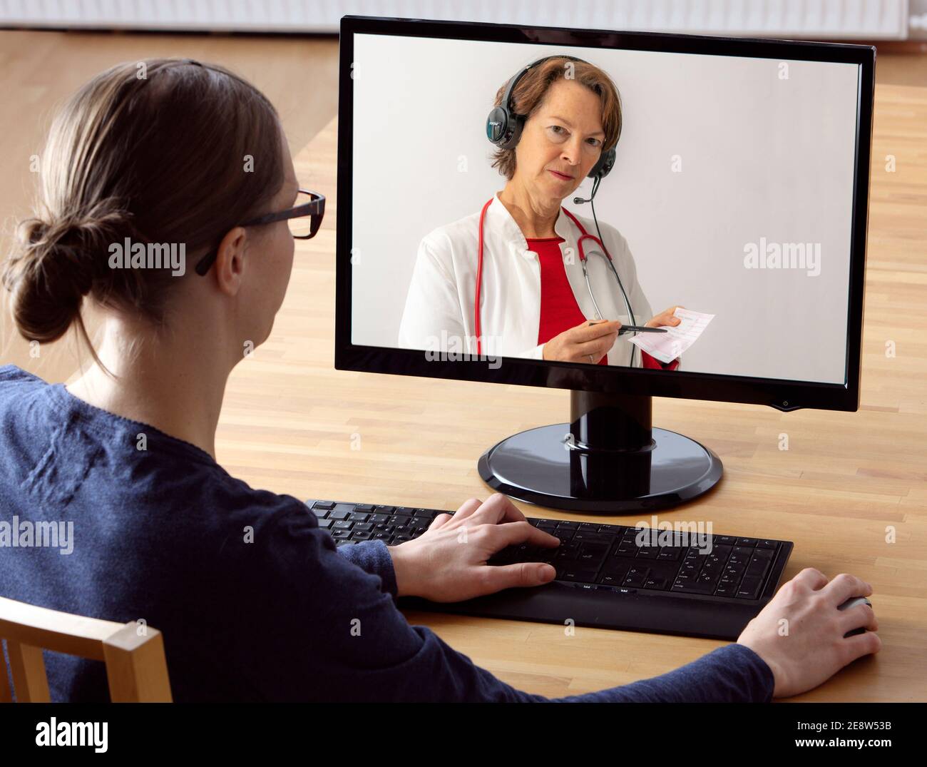 Image symbolique de la télémédecine, le patient parle à un médecin lors d'une vidéoconférence, de chez lui, Banque D'Images